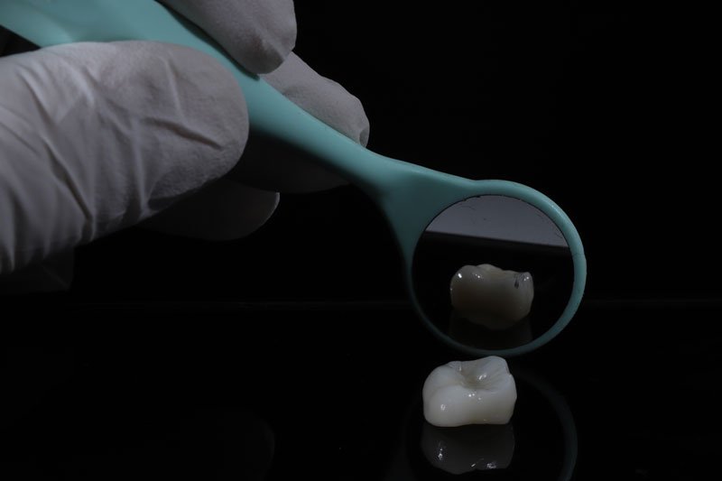 a dental crown being show with a mirror behind it