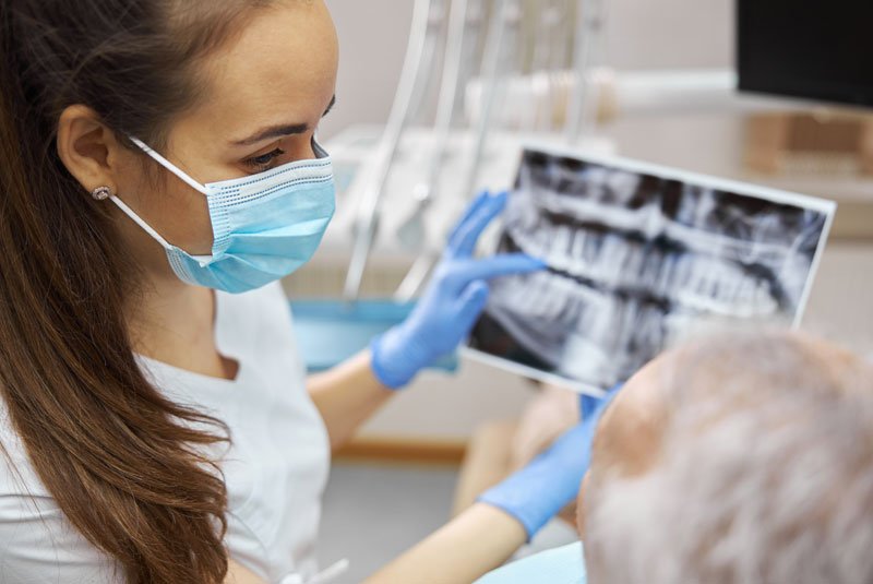 dentist showing xray to denture patient