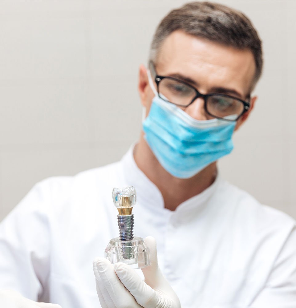 dentist with implant model being held