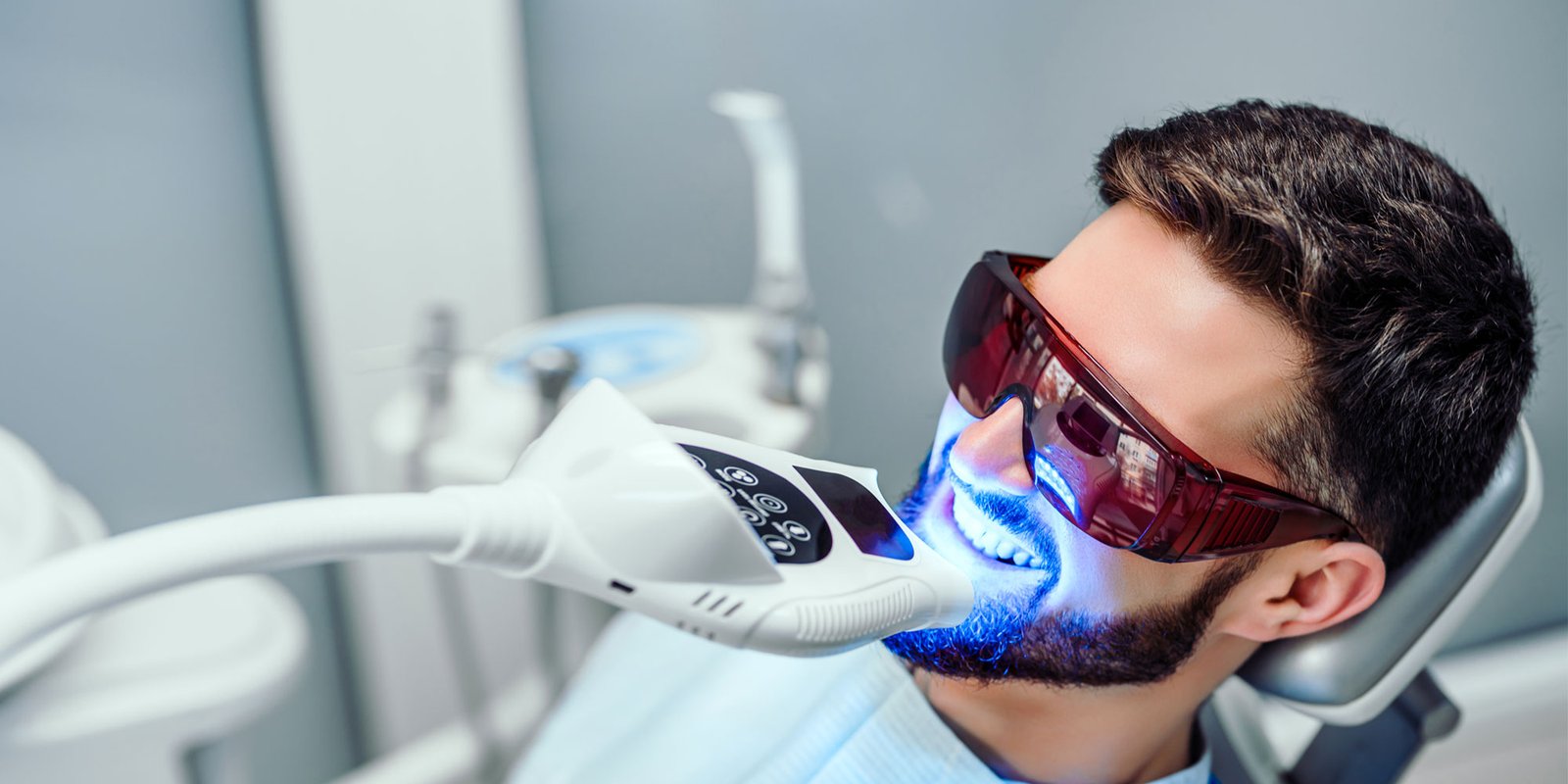 laser teeth whitening procedure with dental patient