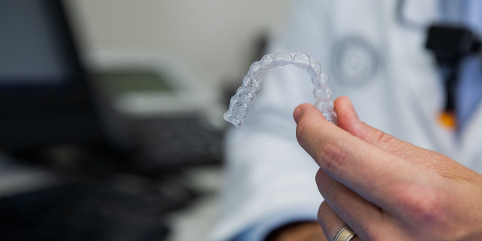orthodontic aligner being held by dentist